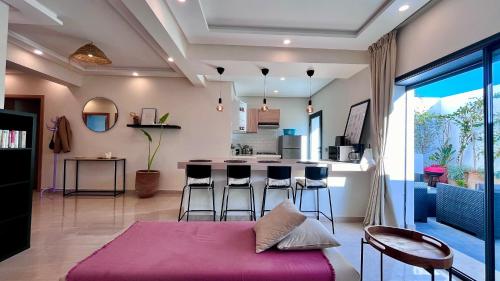 达布阿扎Welcome to your happy place !的一间带紫色床的客厅和一间厨房