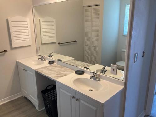 塞巴斯蒂安Sebastian Gardens Inn & Suites的一间带两个盥洗盆和大镜子的浴室