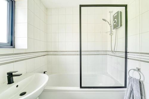 沃尔索尔Stylish 1BR Apartment - Parking - Netflix的白色的浴室设有浴缸和水槽。