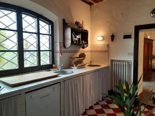 圣焦万尼达索Villa La Consuma : casa storica in paese, giardino, piscina, WiFi的厨房设有水槽和窗户。