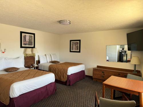 AlbanyRoyal Inn的酒店客房设有两张床和一张桌子。