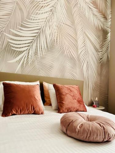 列日Charmant petit appartement.的一张带两个枕头的床和一幅棕榈叶画