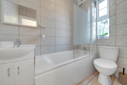 伦敦ADINA 3 Bed Apartment Tower Bridge by London Bridge -Perfect For Long Stays的白色的浴室设有浴缸、卫生间和水槽。