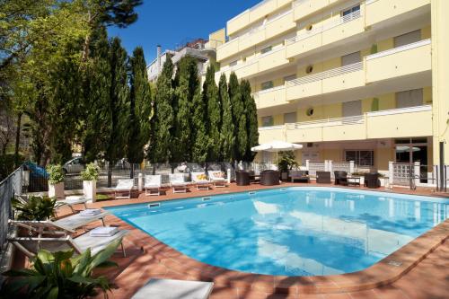 里米尼阿索托丽亚套房酒店的大楼前的大型游泳池