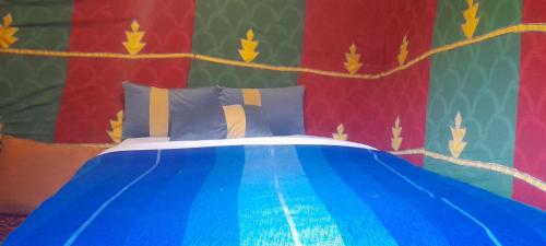 梅尔祖卡Erg Chebbi Starlight Camp的一间卧室配有一张带彩色墙壁的床