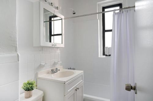 纽约105 -5G Brand New Studio prime location Elevator的白色的浴室设有水槽和镜子
