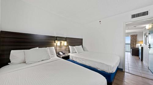 弗吉尼亚海滩SureStay Studio by Best Western Virginia Beach Oceanfront的酒店客房设有两张床和一个阳台。