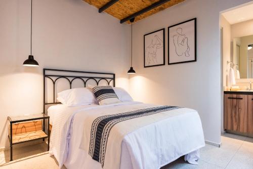 瓜达拉哈拉Casa Murmullos的一间卧室配有一张带白色床单的大床