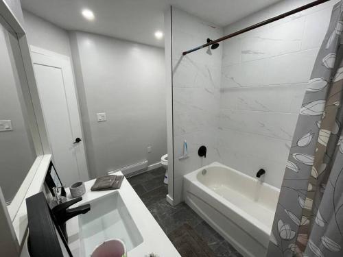 CochraneBrand New Modern unit in town!的白色的浴室设有浴缸和淋浴。