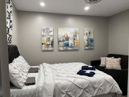 CochraneBrand New Modern unit in town!的卧室配有一张床,墙上挂有四幅画作