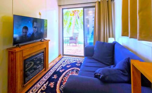 平圭The Zanzibar Beach House-South的客厅配有蓝色的沙发和平面电视。