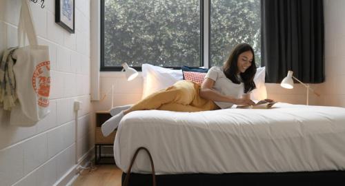 悉尼邦迪海滩村旅舍的坐在床上读书的女人