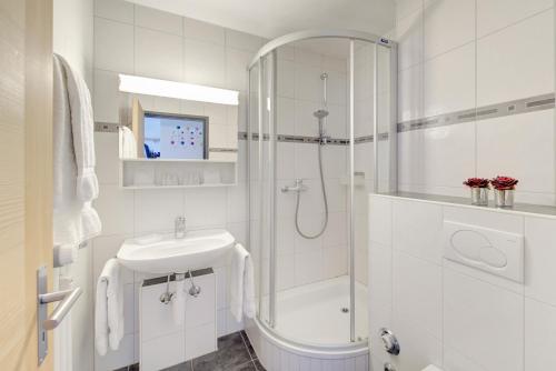 采尔马特Good Value Apartments by Mountain Exposure的带淋浴和盥洗盆的白色浴室