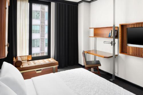 纽约Le Meridien New York, Central Park by Marriott的配有一张床、一张书桌和一扇窗户的酒店客房
