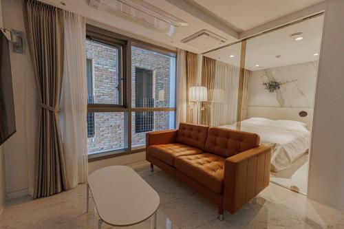 首尔Wecostay Gangnam的客厅配有沙发和1张床