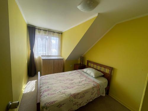 塔尔卡Casa Talca的一间卧室配有一张黄色墙壁的床