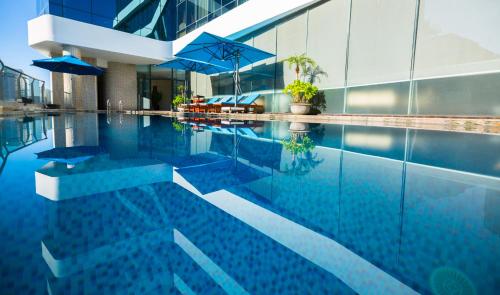 岘港阿凡达岘港酒店的一座带遮阳伞的游泳池以及一座建筑