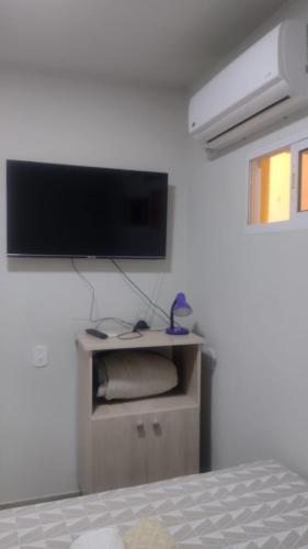 乌鲁瓜亚纳Casa confortável!的卧室配有壁挂式平面电视