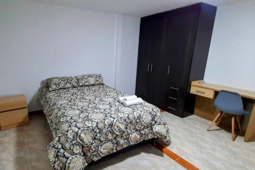 伊皮亚莱斯Hermoso Apartamento en Ipiales的一间卧室配有一张床、梳妆台和书桌