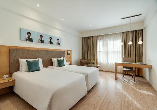 钦奈晨奈绿色公园酒店的酒店客房设有一张白色大床和一张书桌