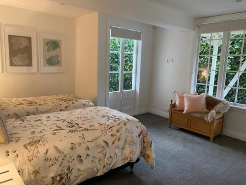 奥克兰Thornleigh的一间卧室设有两张床、一把椅子和窗户。