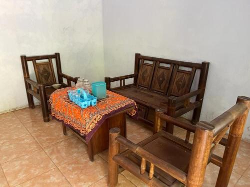 NgadipuroOYO 93784 Kost Bu Eli Syariah的一间设有两把椅子、一张桌子和一张桌子及椅子的房间