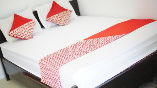 NgadipuroOYO 93784 Kost Bu Eli Syariah的一张带红色和白色枕头的床