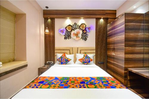 加尔各答FabHotel Prime Jalsa的一间卧室配有一张带彩色毯子的床