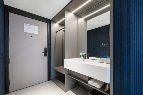 成都成都双流机场锦华路轻居酒店的浴室设有白色水槽和镜子