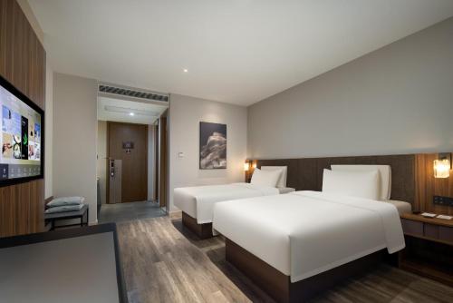 杭州杭州滨江火炬大道亚朵X酒店的酒店客房设有两张床和一台平面电视。
