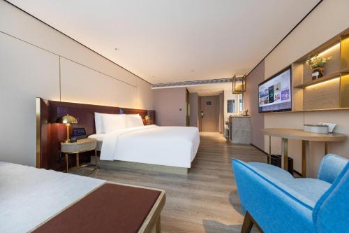 海口海口国贸中心亚朵X酒店的酒店客房设有一张大床和一台电视机。