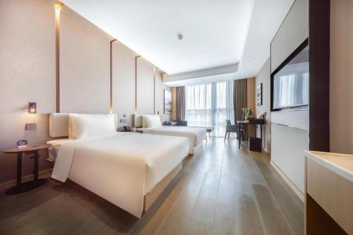 南京南京软件大道地铁站亚朵酒店的酒店客房设有两张床和一张桌子。