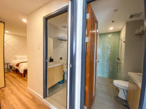 马尼拉Wesfame Suites的带淋浴和卫生间的浴室以及1张床。