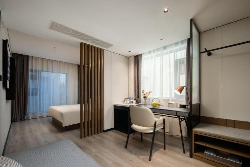 三亚三亚湾凤凰路亚朵酒店的酒店客房设有一张桌子、一张床和一间卧室。
