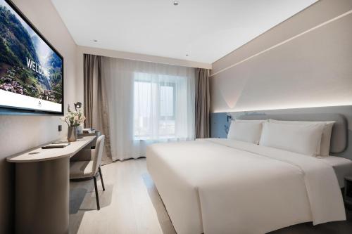 成都成都双流机场锦华路轻居酒店的酒店客房设有一张白色大床和一张书桌