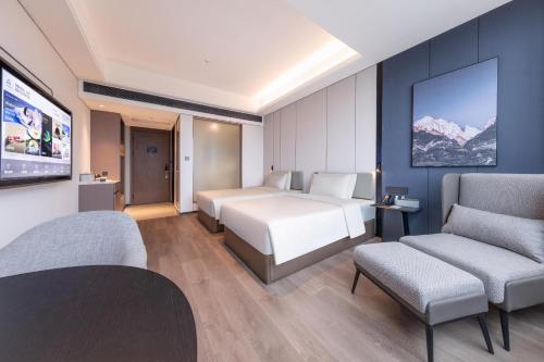 广州广州大道南琶洲会展中心亚朵X酒店的酒店客房,配有一张床和两把椅子