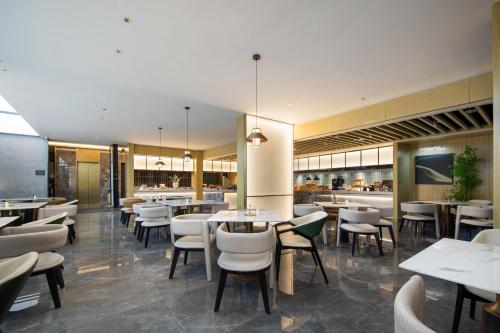 三亚三亚湾凤凰路亚朵酒店的一间带桌椅的餐厅和一间自助餐厅