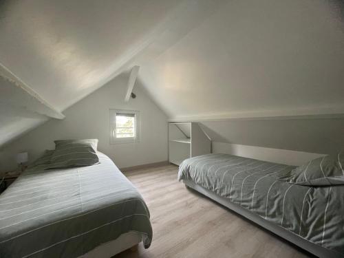 吉维尼Cosy Giverny的阁楼卧室设有两张床和窗户。