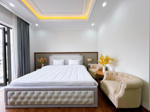 下龙湾Phượng Hoàng villa的一间卧室配有一张大床和一把椅子