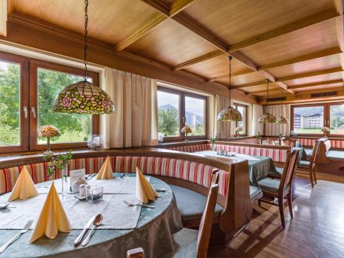 蒂罗尔州基希多夫纽沃特酒店的用餐室设有桌椅和窗户。