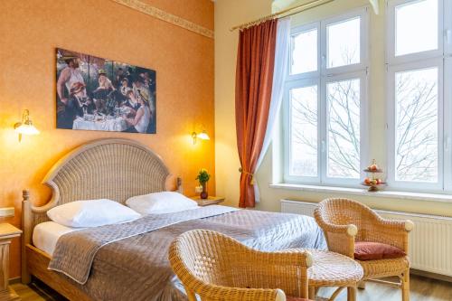 韦尼格罗德Schlossberg-Hotel Garni的一间卧室配有一张大床和两把椅子