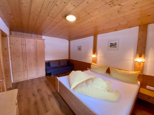 朗根费尔德Apartment Seespitz的一间带一张床的卧室,位于带木制天花板的房间内