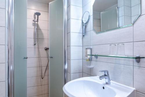 韦尼格罗德Schlossberg-Hotel Garni的白色的浴室设有水槽和淋浴。