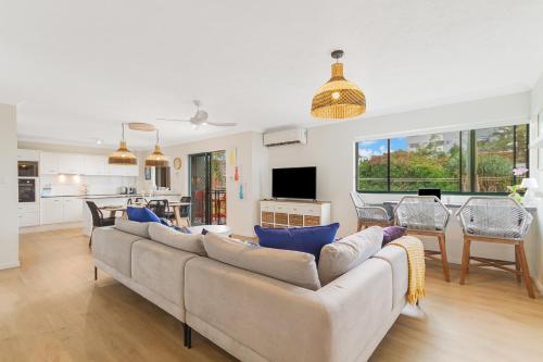 黄金海岸Bilinga Bliss - Luxury beachfront apartment的客厅配有沙发和桌子