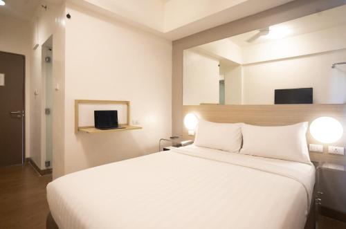 马尼拉Red Planet Manila Malate Mabini的卧室配有白色的床和镜子