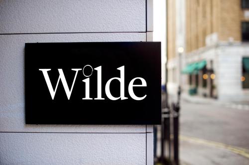 伦敦Wilde Aparthotels London Covent Garden的建筑物一侧的妻子的标志