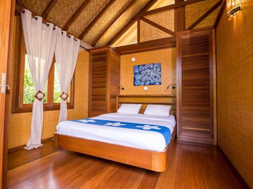 FarinoOasis de Tendéa - Bali à Farino的一间卧室设有一张床和一个窗口
