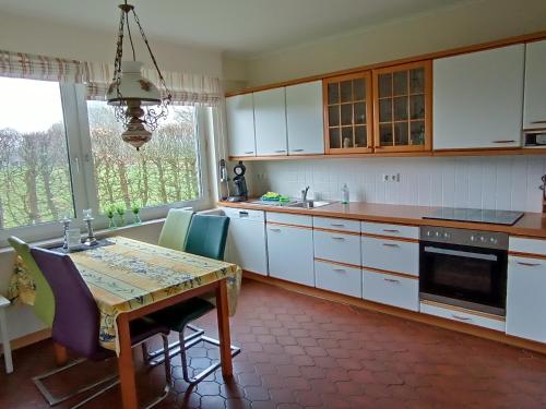 拉奥德芬Ediths Haus的厨房配有白色橱柜和桌椅