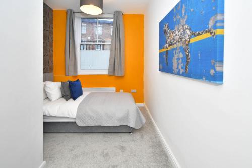 特伦特河畔斯托克K Suites - Westport Road的一间卧室拥有橙色的墙壁、一张床和窗户