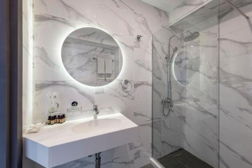 第比利斯Hotel Address 9D的白色的浴室设有水槽和淋浴。